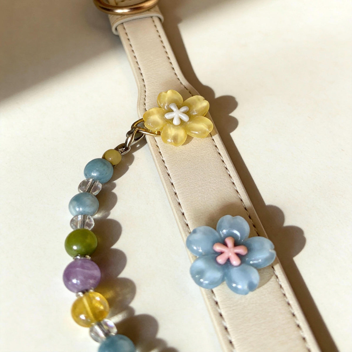 Close detail view of cream leather pet collar with flower embellishments and vibrant jade bead chain | DIY Jade
