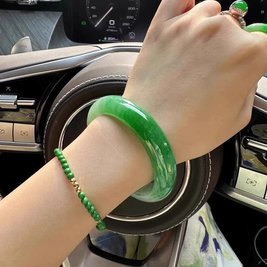 Natural emerald green jadeite bangle bracelet worn on wrist, lifestyle shot in car interior | DIY Jade