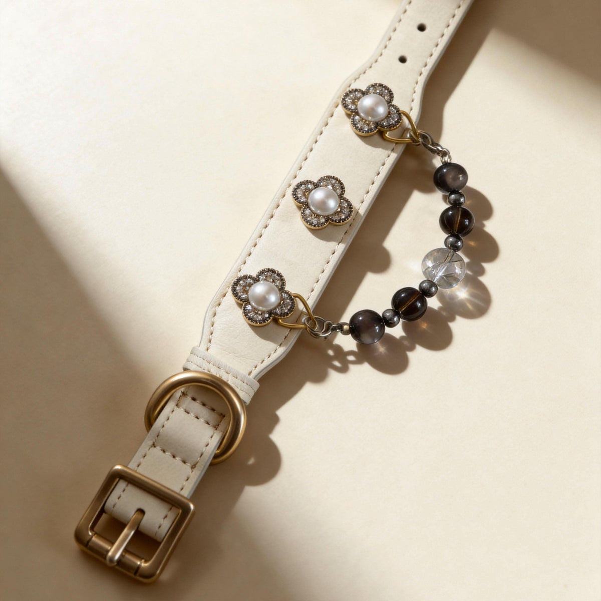 Flat lay view of cream leather pet collar with clover pearl hardware and smoky jade beads | DIY Jade
