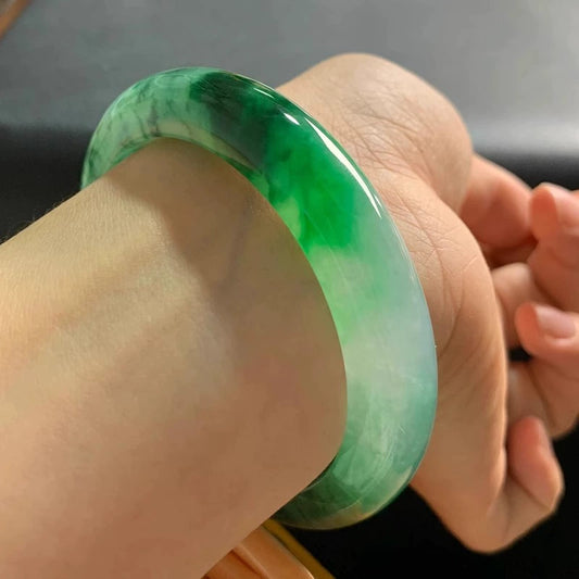 Green floating flower jadeite bangle worn on wrist, showing elegant everyday fit | DIY Jade
