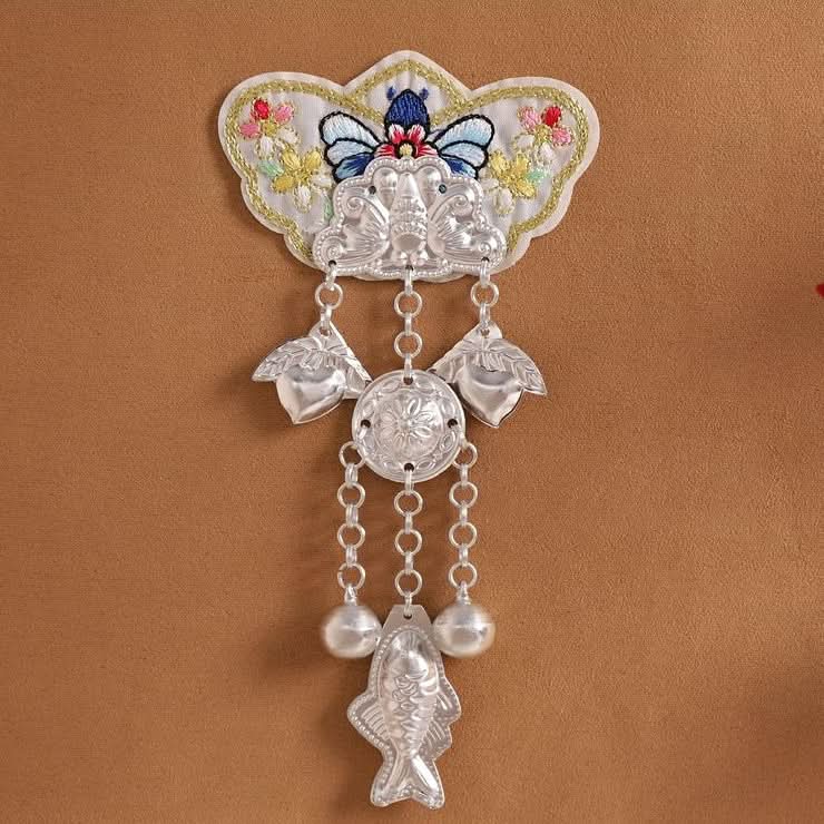 Tall vertical chain‑hung applique, stacked silver charms,