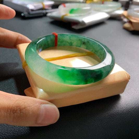 Icy translucent green floating flower jadeite bangle on display stand with red string tag | DIY Jade