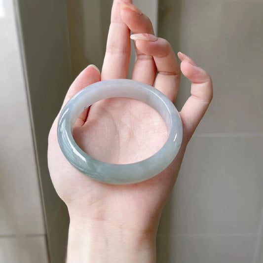 Natural icy pale blue-green jadeite bangle, held in hand to show full shape and color | DIY Jade