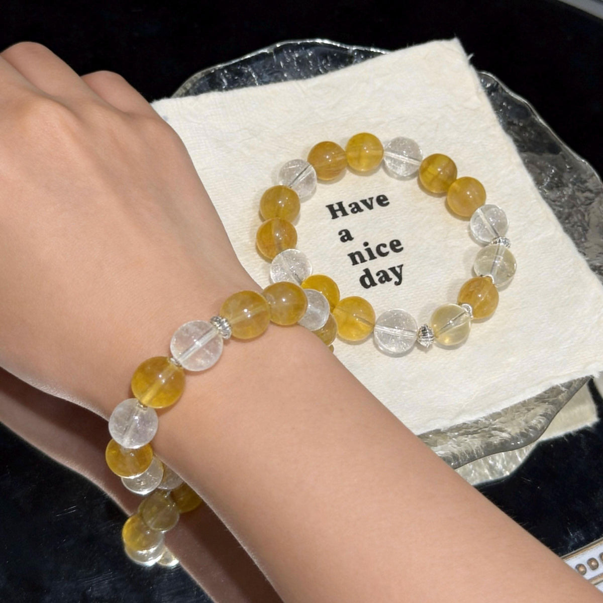 Owner wearing yellow fluorite and white agate crystal bracelet with matching pet collar on a round display tray | DIYJade