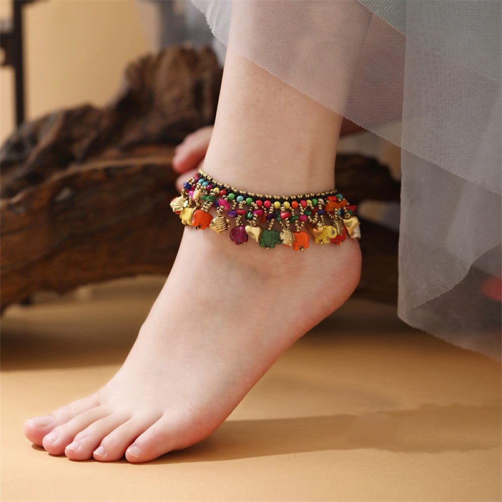 This vibrant multi-layered necklace features a rich mix of colorful beads and playful elephant charms in red, yellow, white, and turquoise