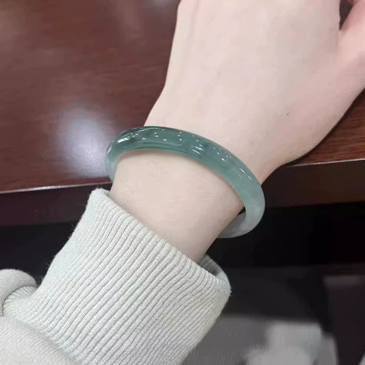 Natural oil green jadeite bangle bracelet, lifestyle shot worn on wrist at desk | DIY Jade
