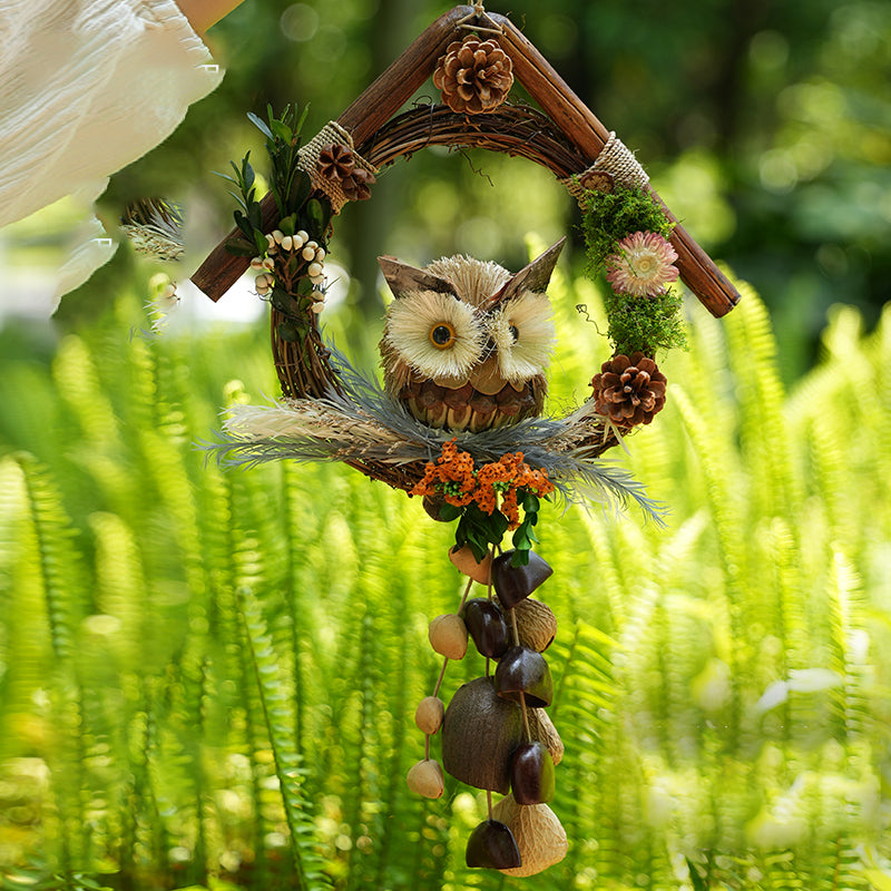Owl themed decorative seed pod wind chime in lush green grass setting | DIY Jade
