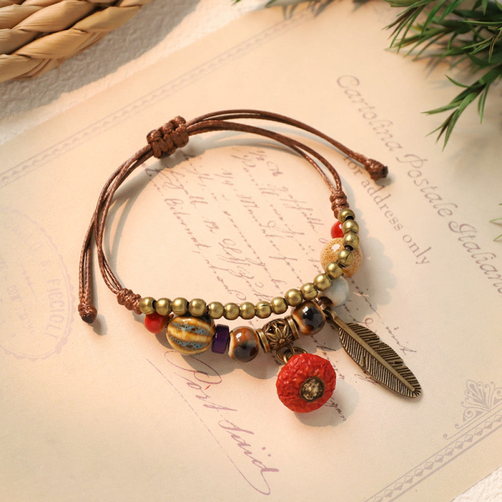 Woven boho bracelet with red flower charm and feather | DIY Jade
