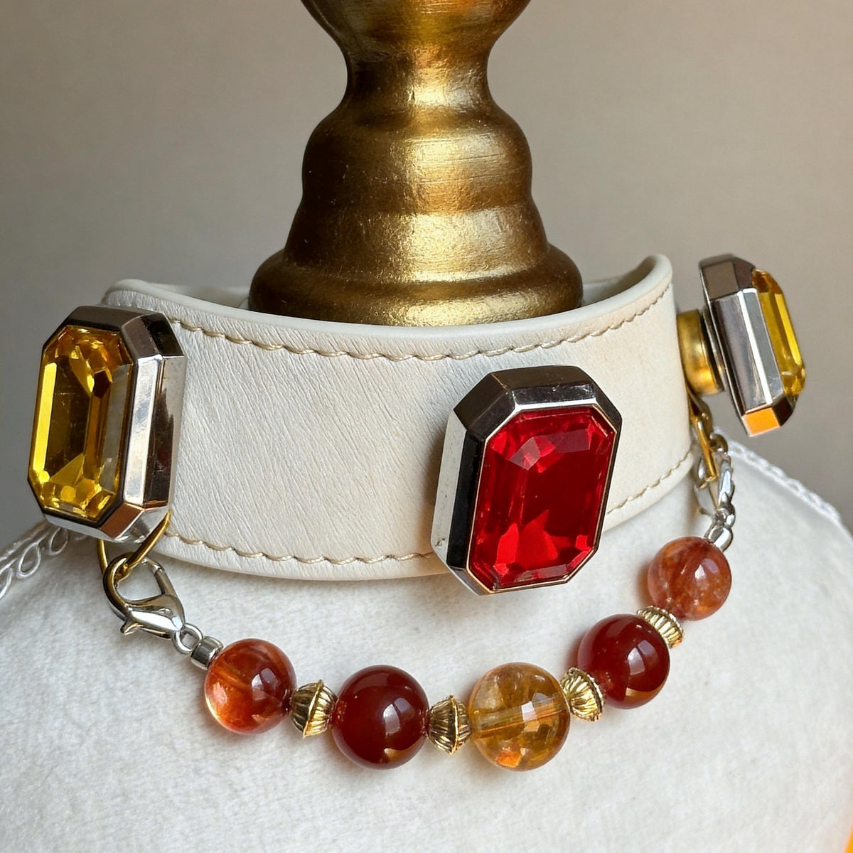 Close-up of gold-tone cat collar clasp with red gemstone, amber beads, and leather-style band | DIYJade