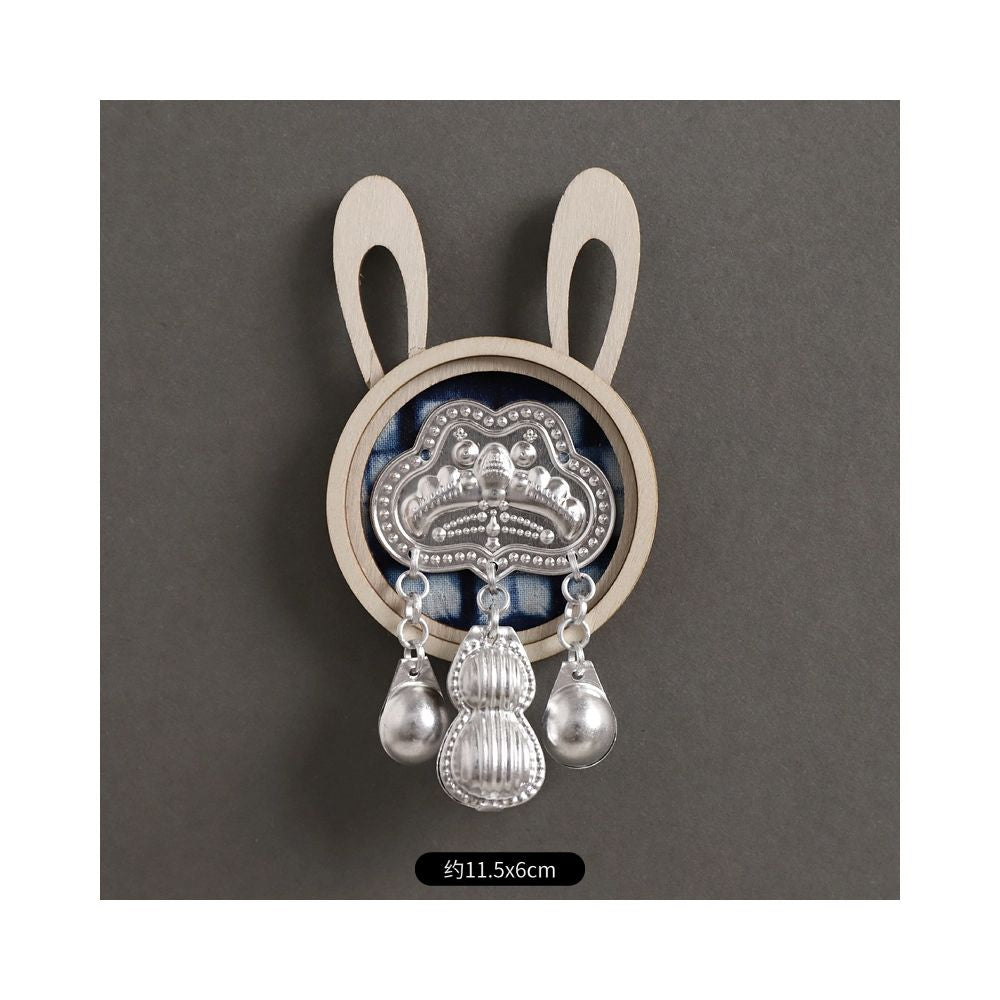 Round silver brooch with single tassel