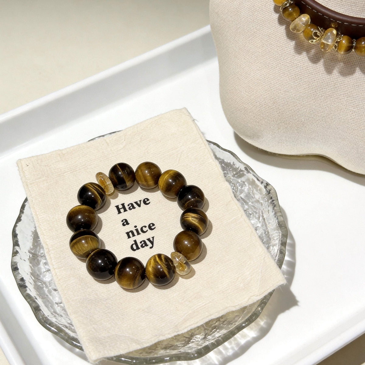 Tiger‑eye round bead human bracelet laid on paper note over glass plate | DIY Jade