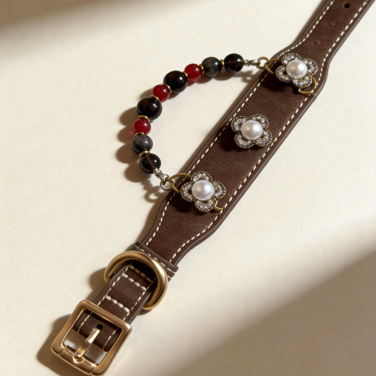 Flat lay shot of vintage leather pet collar with pearl decor and red brown jade beads | DIY Jade