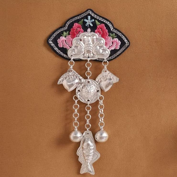 Upright chain‑style embroidered applique, sequential silver pendant dangles, minority craft