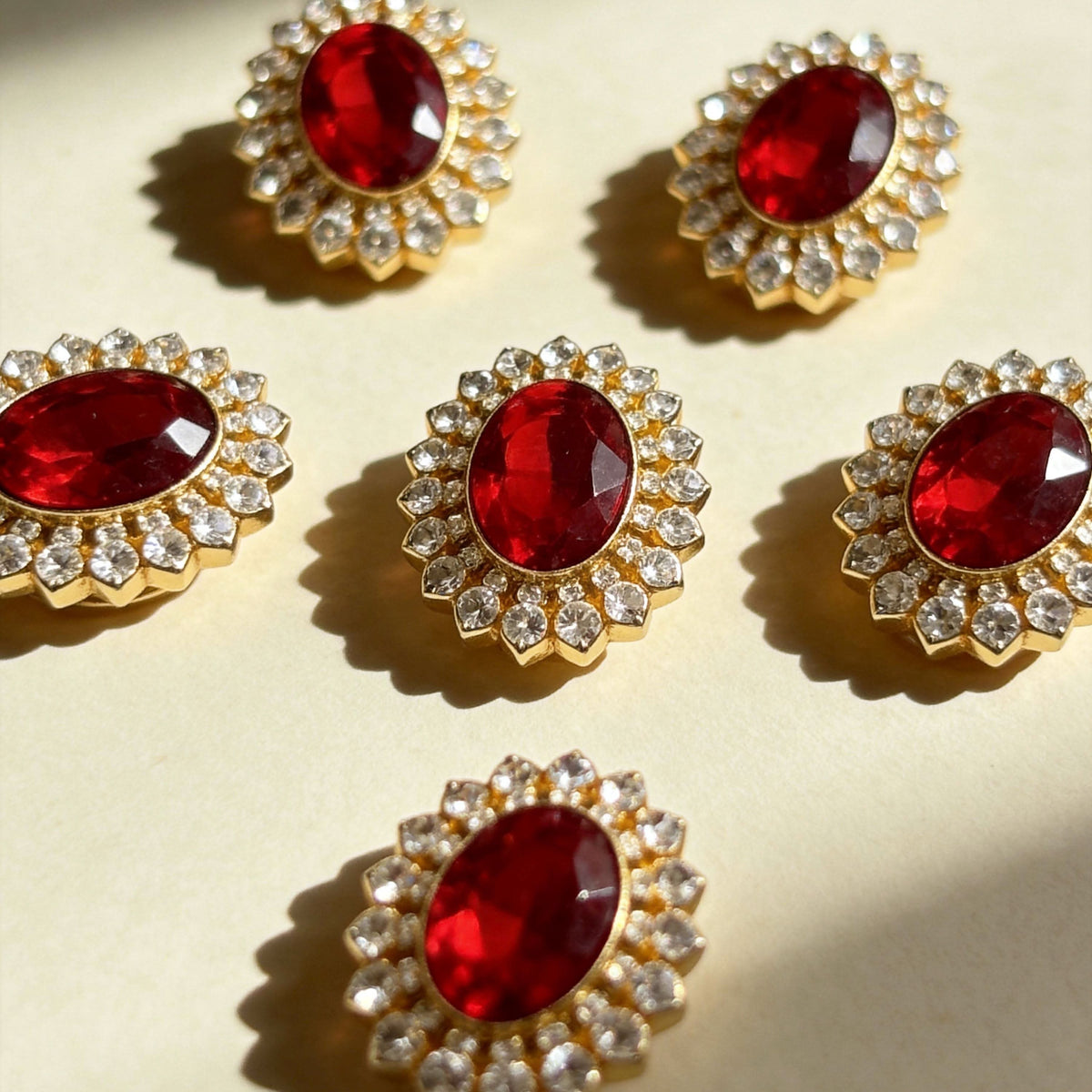 Vintage gold‑toned oval red rhinestone sunburst charms for pet collars flat lay | DIY Jade